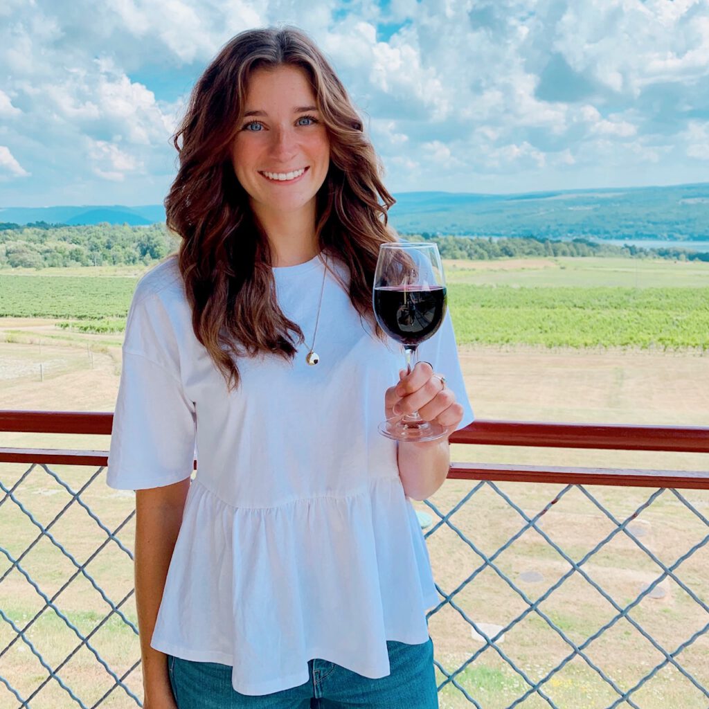 Director of Marketing Jessie smiling with a glass of wine