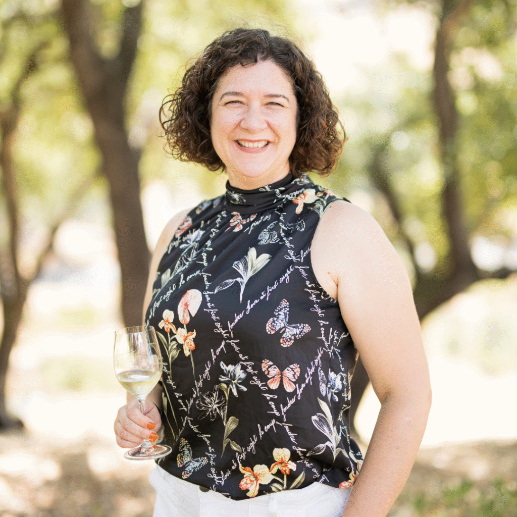 Consulting winemaker Nova smiling with a glass of wine