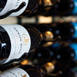 Heron Hill reserve wine bottles on rack.