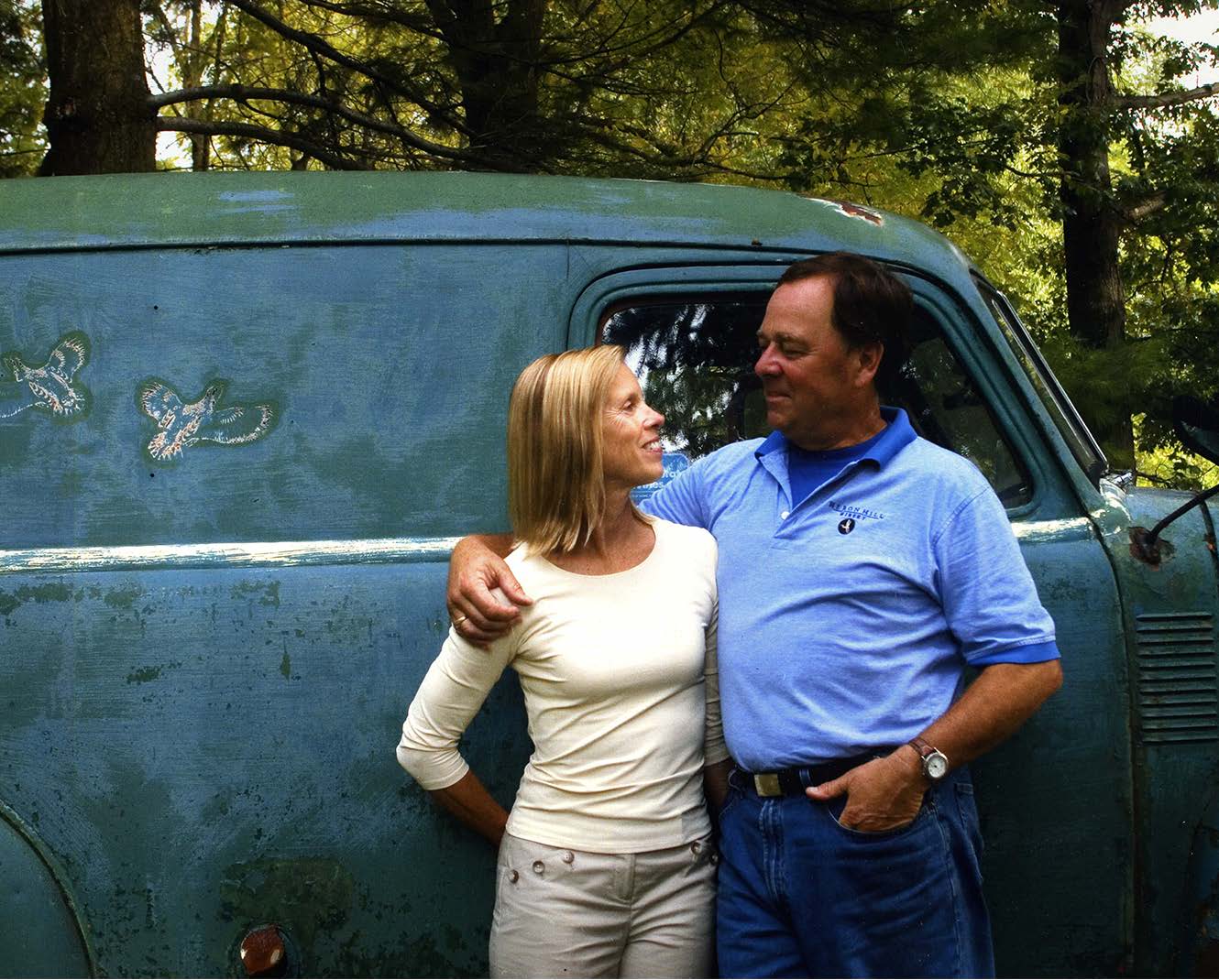 Owners John and Jo Ingle looking at each other next to an old truck